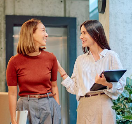 Two women walking in the workplace.