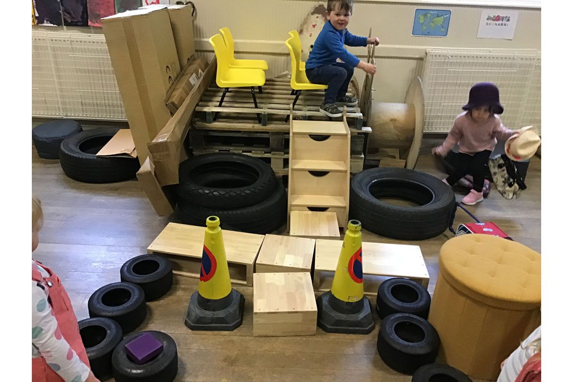 Children play in car made of boxes and pallets