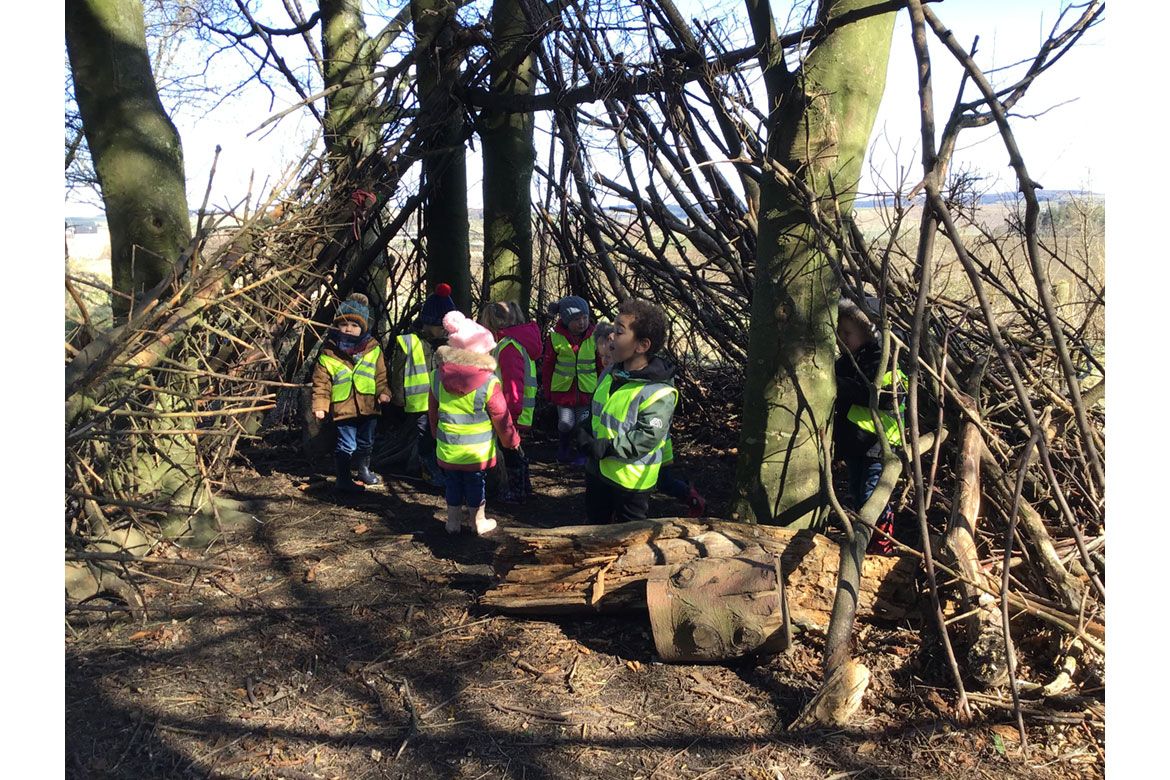 Children play in an outdoors den