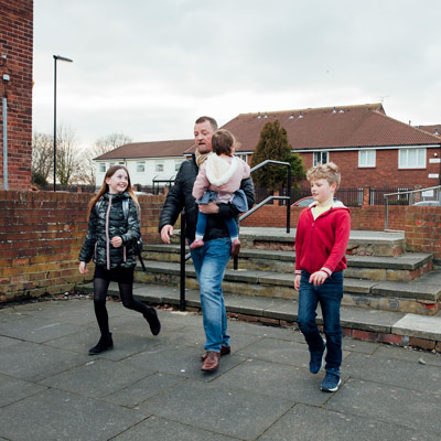 A dad walks home from school with 3 children